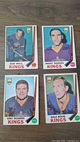 Front sides of four 1969 OPC LA Kings hockey cards featuring Bob Wall, Brent Hughes, Gerry Desjardins, Dale Rolfe with player portraits and team branding.