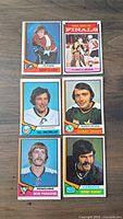 Front sides of 6 hockey cards featuring players Bobby Clarke, Bill MacMillan, Danny Grant, Bob Paradise, Dennis Kearns and 1974 Flyers vs Bruins Finals card.