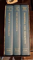 Spine view of the 3-volume set with titles and volume numbers clearly visible
