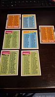 Photo showing all 7 unmarked football card checklists arranged in a semi-group with clear text and colored headers.