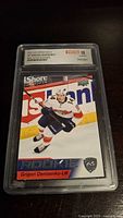 Front of 2021-22 Upper Deck Grigori Denisenko rookie card in WCGC holder, graded 10.