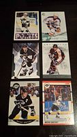 Photo showing six different Wayne Gretzky hockey cards arranged in two columns and three rows on a black surface.