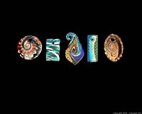 Five assorted glass blown pendants arranged in a row on a black background showing detailed colors and shapes.