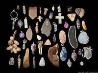 Top-down image showing all gemstone pendants spread out on a black background, includes various shapes and styles with metal bails.