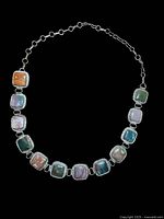 Full view of vintage silver belt with 12 linked square gemstones in different colors and silver settings, showing the whole piece on black background.