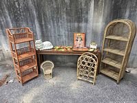 Full lot view showing the two collapsible wicker shelves (orange and natural), doll sized wicker chair, ceramic cat, vintage wine rack and various small decor on bench