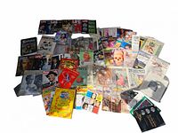 Wide view of the large collection of vintage magazines, sheet music, and art books spread out, showing a variety of covers and subjects.