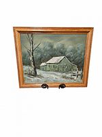 Front view of the framed oil painting showing a snowy barn scene with trees and a fence under a cloudy sky.