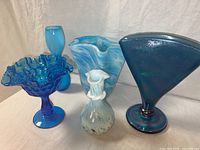 Overview of all five blue art glass pieces showing varied styles and finishes.