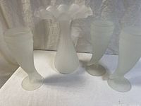 Set showing one frosted glass fluted vase with ruffled edge and three horn-shaped frosted glass goblets arranged side by side.