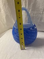 Front and side view of cobalt blue and white swirled glass basket with twisted clear glass handles, measuring approx. 7 inches tall