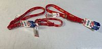 Three red San Francisco 49ers dog collars laid out, showing tags and logos, all new condition.