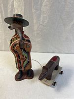 Full view of the coyote figurine in colorful poncho pulling a bear on wheels by string, showing the entire lot