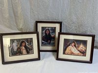 Three framed Indigenous American art prints arranged side by side. Prints feature women with symbolic backgrounds; frames are dark wood with white mattes.