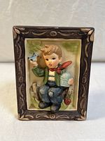 Front view of the vintage ceramic 3D boy wall plaque in faux-wood sculpted frame