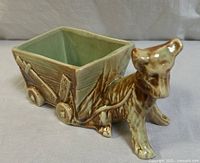 Front side view of the McCoy donkey and cart ceramic planter showing donkey detailed texture and wooden cart design, glossy brown exterior, and green interior glaze.