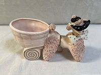 Full side view of vintage pink ceramic poodle planter showing textured fur, basket bowl, spiral wheel detail, sunglasses, and bow tie.