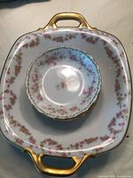 Photo of the stacked dessert bowls inside the serving bowl showing the floral pattern and gold rims on white ceramic with gold handles on serving bowl.