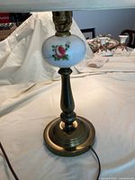 Photo showing the full lamp without the shade, highlighting the brass base and the floral glass accent below the socket.