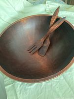 Top view showing interior of wooden salad bowl with wooden salad fork and spoon servers inside