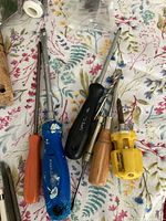 Various screwdrivers with orange, blue, black, wooden, and yellow handles including small precision cutting tools