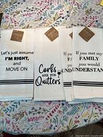 Four white tea towels laid out showing full text prints and tag labeled Mabellé