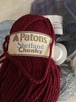 Close-up of deep red Patons Shetland Chunky yarn skein showing label