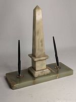 Front view of alabaster obelisk and fountain pen set on rectangular base.