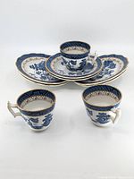 Blue and white china tea set with 3 cups and 6 plates, ornate oriental design and gold trim.