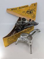 Photo showing the vintage Mouli Julienne shredder with multiple blades and original yellow box with graphic instructions and wear.