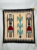 Full front view of entire rug hanging against backdrop