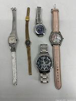 Full view of all five watches showing varied styles and bands, some wear visible