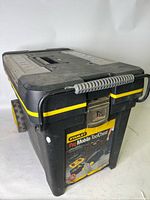 Front angled view of the black and yellow Stanley Pro Mobile ToolChest with handle and wheels visible, showing some paint marks and sticker residue.