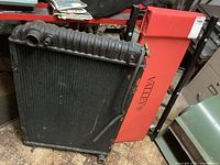 Photo showing the radiator leaning against the Valley creeper with red padding visible, radiator appears used with some wear.