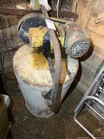 Overall view of cement mixer drum with attached electric motor and belt-drive assembly.