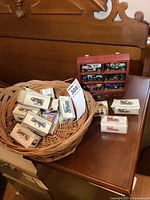 Photo showing nine collectible model cars in original boxes with a red wooden display shelf containing six cars, rest in boxes.