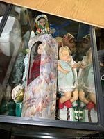 Top-down view of several dolls, one boxed and others loose with detailed clothing