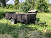 Side view of entire trailer and plywood box in grassy setting