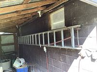 Full view of ladder hung horizontally against shed wall