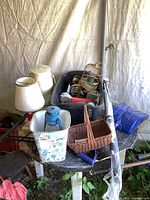 Blue barn lantern, umbrellas, baskets and bird feeder on table with some small items
