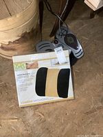 Image of Conair Lumbar Massaging Cushion box showing product branding and features with attached foot massager controls visible in background.