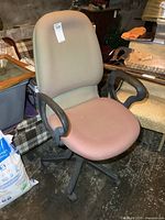 Side angle view of the chair showing the dual-tone upholstery, armrests, and black wheeled base.