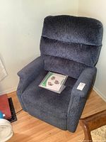 Front view of blue upholstered recliner chair in corner