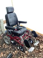 Side and front view of Biswift powered wheelchair with black cushioned seat, armrests, joystick on right armrest, and footrests.