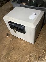 Front view of Sentry 1170 fire resistant safe showing keys in the lock and brand markings.