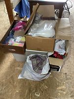 Boxes and tote filled with fabric bundles, batting, and sewing supplies.