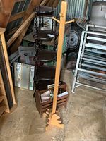 Photo of a wooden kids' coat rack, magazine rack, and dark wood corner tiered shelf arranged together in storage space.