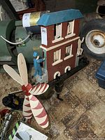 Full front and side view showing painted building structure, characters, and attached large propeller.