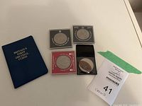 Overview of booklet and four cased coins