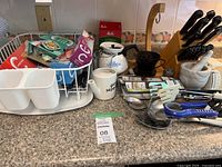 overview of countertop items: knife block, dish rack, utensils, ceramics